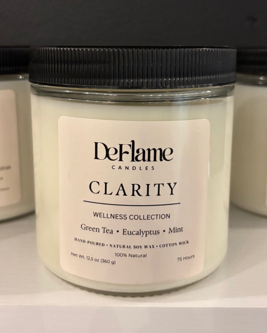 DeFlame Clarity candle with a black lid on a white surface